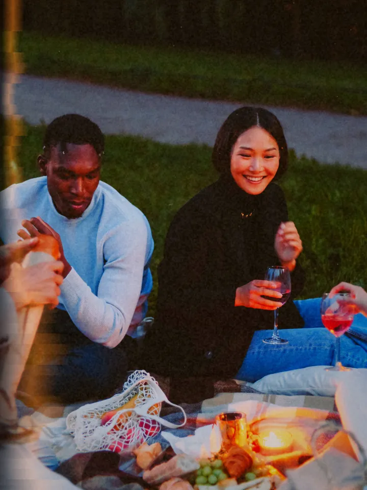 A couple sharing a drink on a picnic blanket at dusk — 1972 · Instant Fold