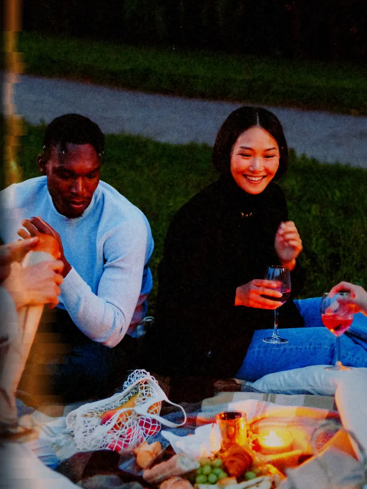A couple sharing a drink on a picnic blanket at dusk — 1998 · Disposable Flash