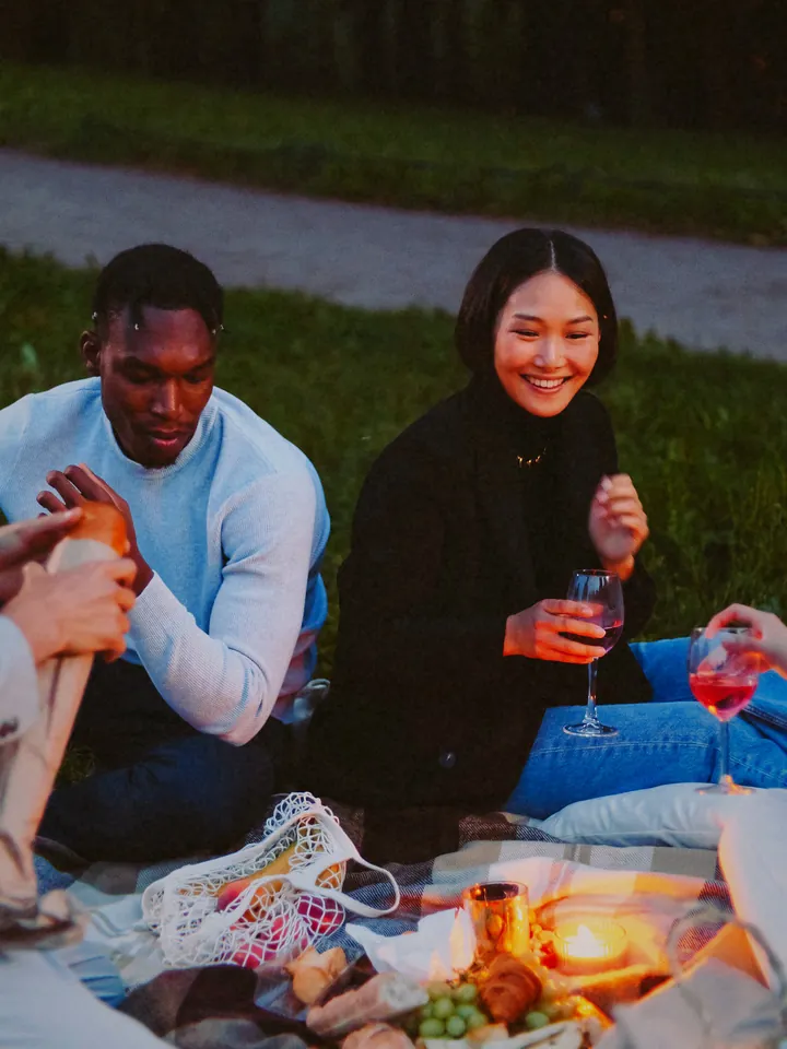A couple sharing a drink on a picnic blanket at dusk — 2010 · Square Feed