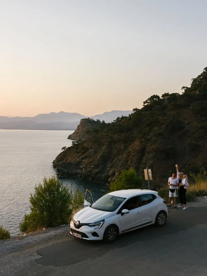 A white car on a coastal road at sunset — Original photograph